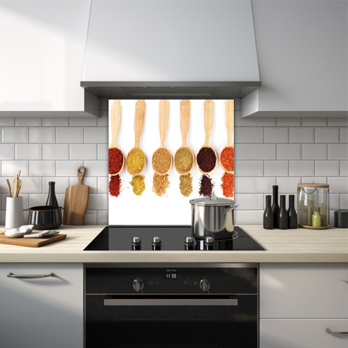 Bright coloured spices on wooden spoons.