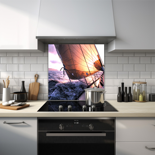 Glass splashback of a sailboat racing on the ocean at sunset.