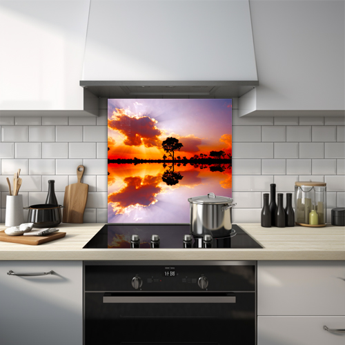 African sunset with tree silhouettes reflected in water glass splashback.