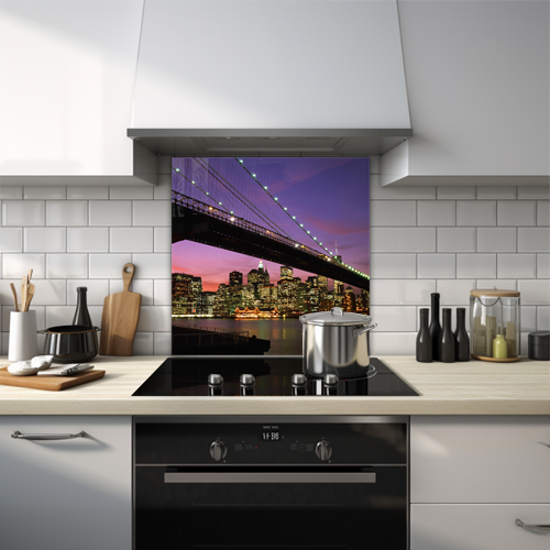 Glass splashback of Brooklyn Bridge at night under a purple sky.