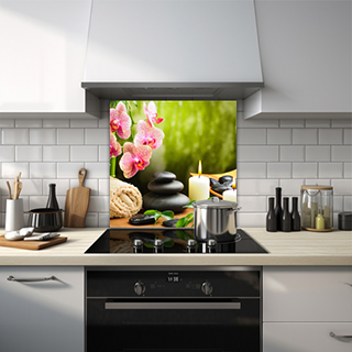 Flower with stacked pebbles and lit candle glass splashback. thumbnail