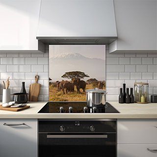 Elephants on African plain with tree and mountain backdrop glass splashback. thumbnail