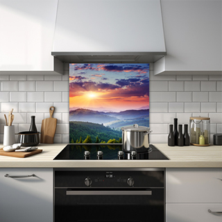 Sun through clouds highlighting a misty green forest from a high vantage point glass splashback. thumbnail